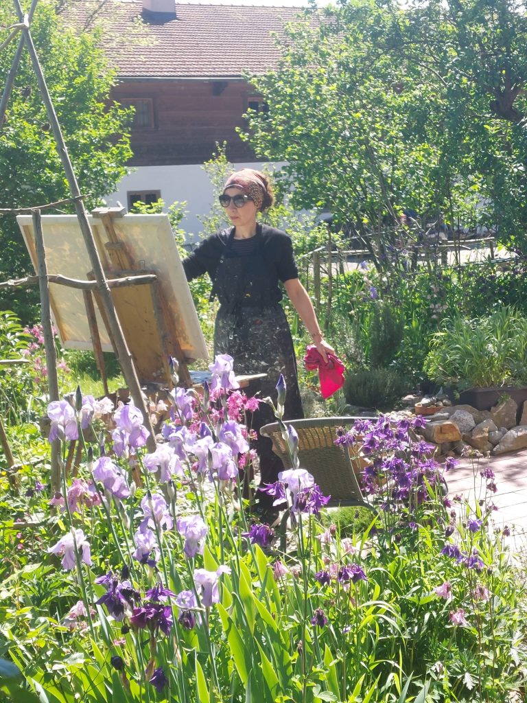 Malerin Elina Deberdeeva beim Malen im Garten