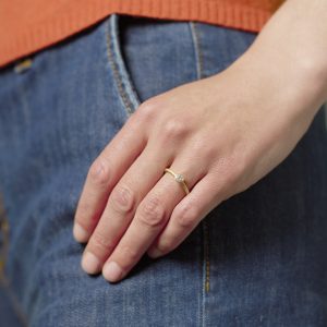 Verlobungsring in Gelbgold mit einem Brillant, getragen an Hand